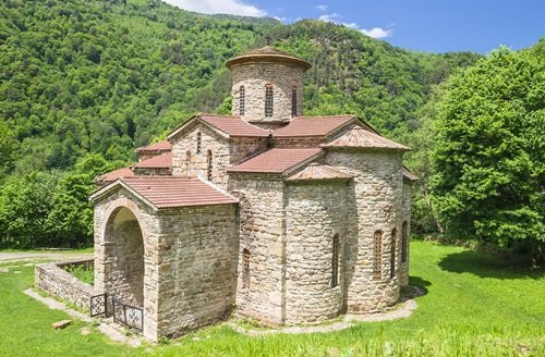 Medieval stone church in the Caucasus mountains, a highlight of the East Site Travel 14-day multi-country tour.
