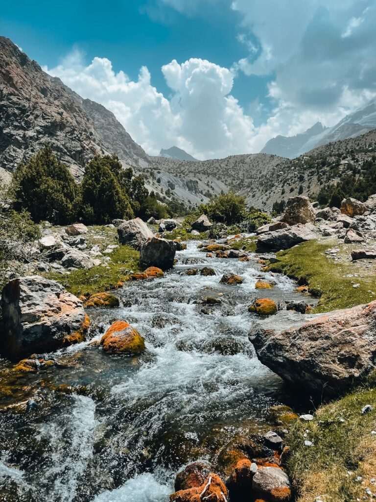 water stream with mountains in the background