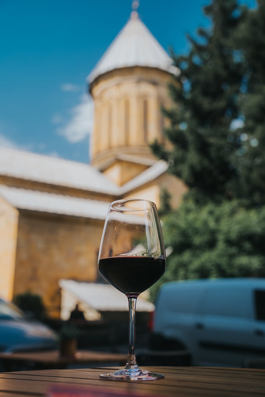 wine glass against tbilisi church at daytime, Photo by Onur Kaya on Pexels.com