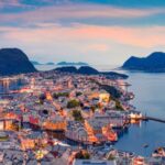 Aerial sunset view of Ålesund, Norway, showing the Art Nouveau architecture and surrounding fjords.