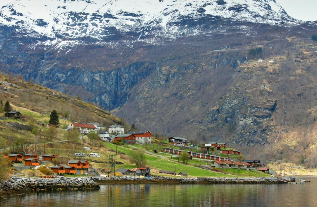 scenic village in norwegian fjord with snowy mountains