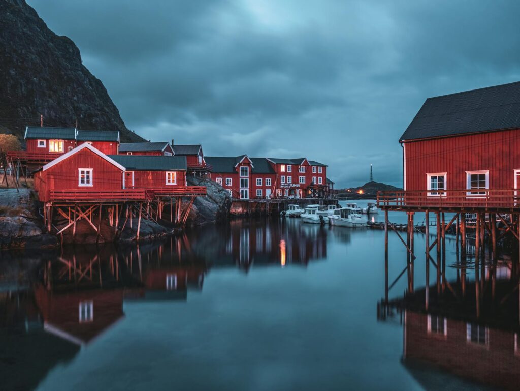 red wooden stilt houses in a norwegian fjord