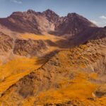 Aerial view of a Kyrgyzstan mountain range in vivid autumn colors