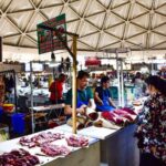 Vibrant scene at Chorsu Bazaar in Tashkent with vendors selling fresh meat