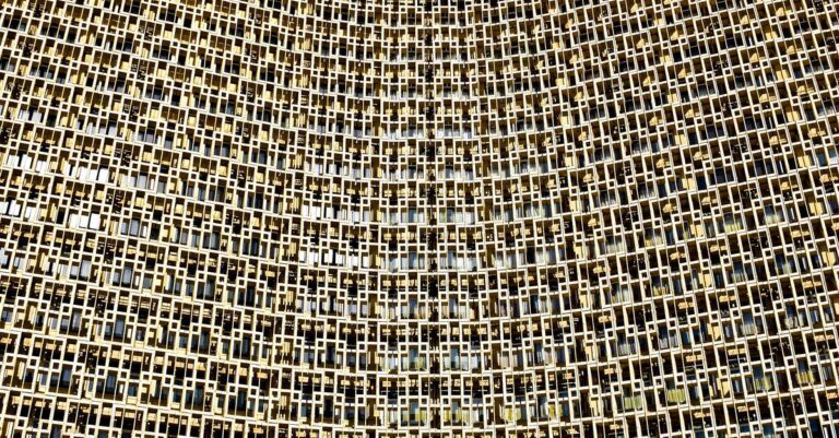The impressive facade of Hotel Uzbekistan in Tashkent against a clear blue sky
