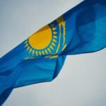 Kazakhstani national flag waving against a clear sky in Almaty