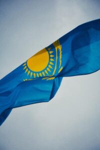 Kazakhstani national flag waving against a clear sky in Almaty