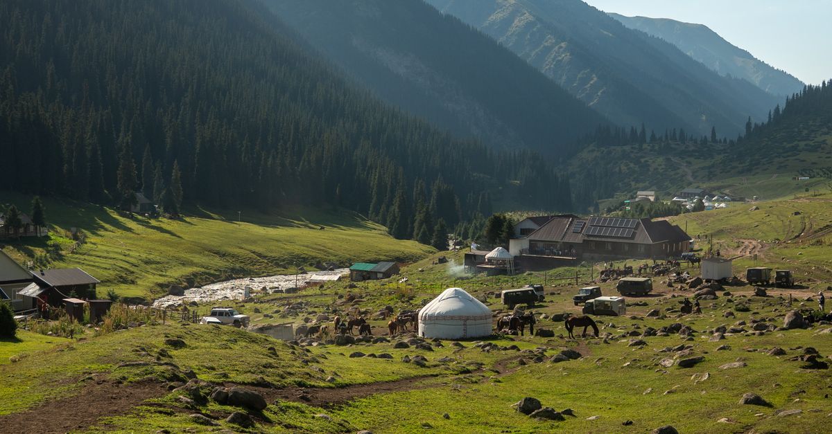 Traditional yurts in a mountain valley in Kyrgyzstan under a clear sky