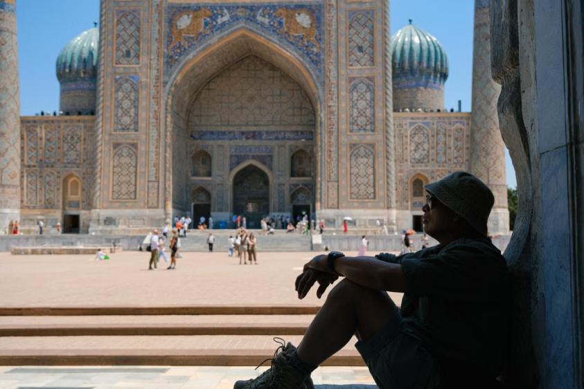 Senior traveler enjoying a moment of pause at a historic Samarkand landmark