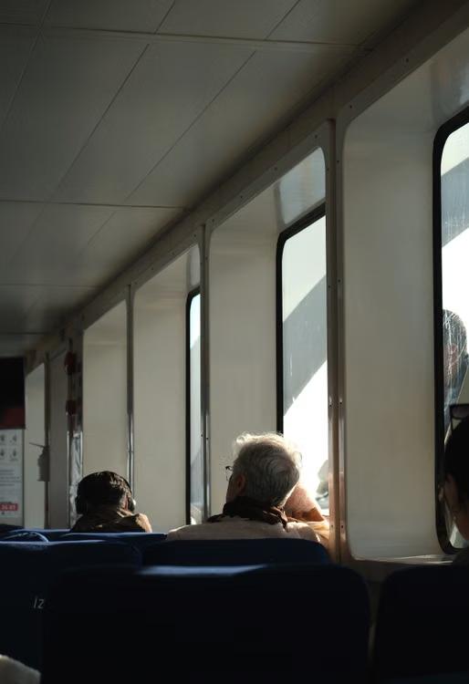 Travelers enjoying a sunny train ride while looking through the windows