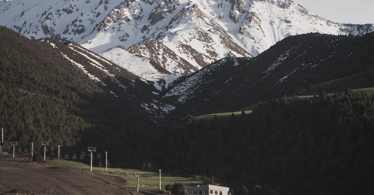 Traditional yurts set against snow-capped mountains in Kyrgyzstan