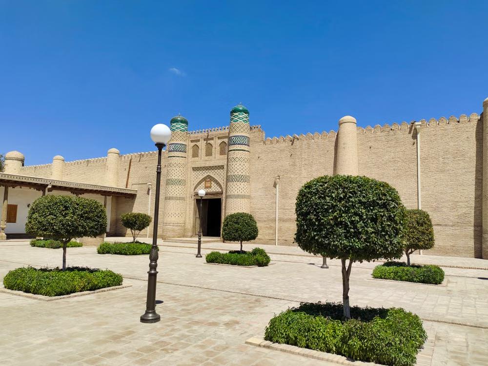 A historic fortress wall in Bukhara, Uzbekistan under a blue sky