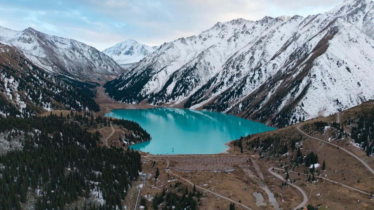 Aerial view of Big Almaty Lake surrounded by snowcapped mountains in Kazakhstan