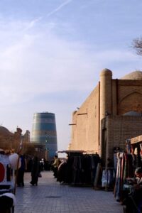 Bustling market street in Khiva with the Kalta Minor Minaret visible in the background