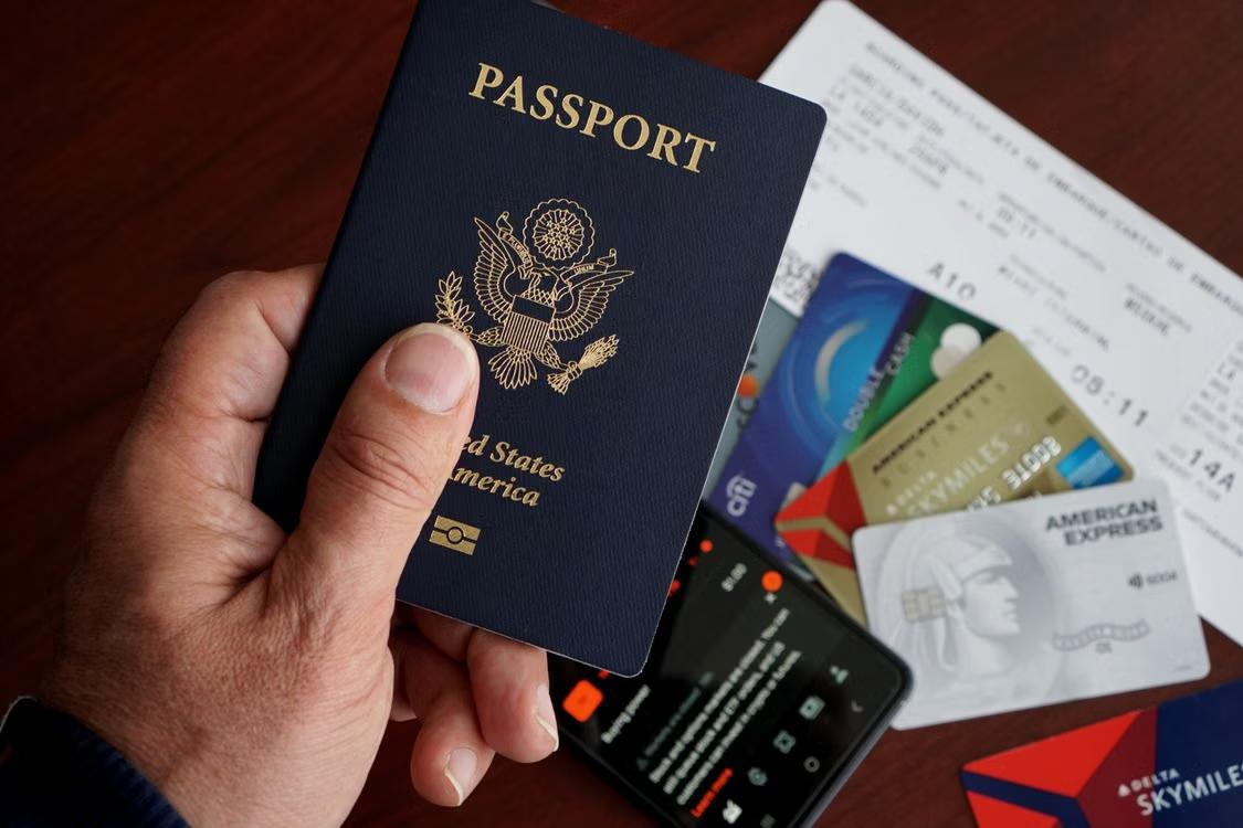 Close-up of a passport and boarding passes resting on top of a laptop