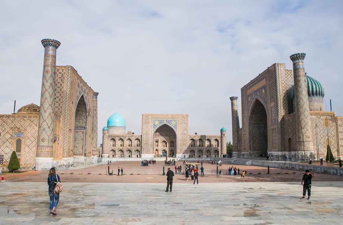 Tourists walking through Registan Square in Samarkand, Uzbekistan