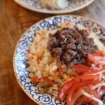 Delicious Uzbek plov with beef, served on a decorative blue plate