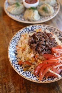 Delicious Uzbek plov with beef, served on a decorative blue plate