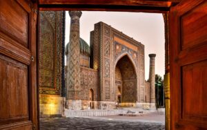 Registan Square in Samarkand, Uzbekistan, with ornate blue tilework, domes, and decorated arches.